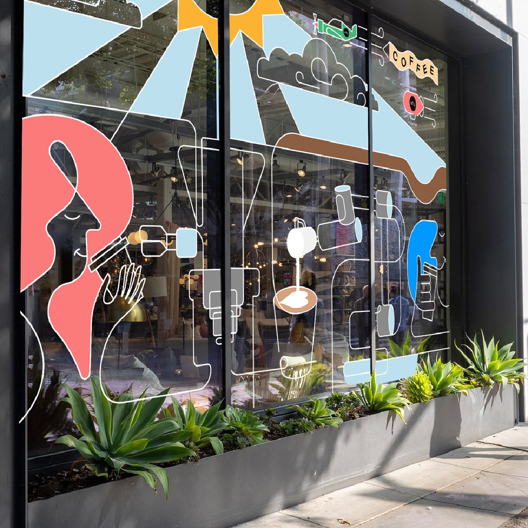 An Artly retail space includes their signature line illustrations along the windows of the storefront. It has pops of color, and green plants line the bottom of the window.
